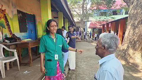 Haritha Karma Sena worker Sindhu O giving directions to an elderly voter at a polling station located in Government High School, Kachani, in Thiruvananthapuram.