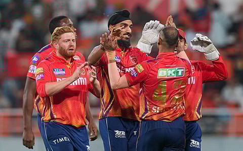 Punjab Kings bowler Arshdeep Singh, captain Shikhar Dhawan and teammates celebrate the wicket of Sunrisers Hyderabad batter Travis Head