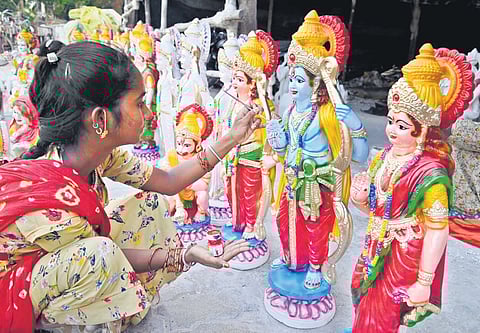 Ahead of Sri Rama Navami, a woman applies final touches to the idols of Lord Rama and Goddess Sita in Karimnagar on Monday