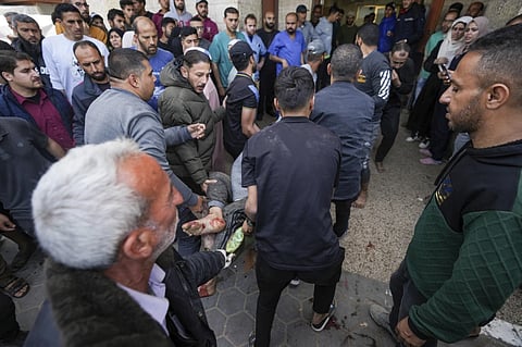 Palestinians carry a wounded person following an Israeli airstrike near the Al Aqsa hospital in Deir al Balah, Gaza Strip, Sunday, March 31, 2024. 