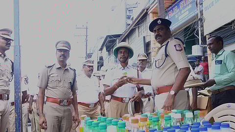 Police officials distributing drinking water and refreshments for Vellore district traffic policemen