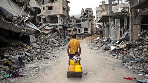 A Palestinian man pulls a cart on a road lined with destroyed buildings in Khan Yunis in the southern Gaza Strip on May 2, 2024, amid the ongoing conflict between Israel and the Hamas movement.