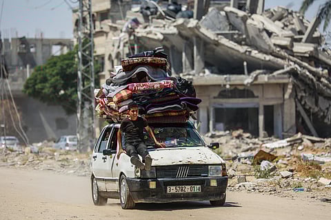 Displaced Palestinians arrive in a car carrying their belongings to set up shelter after returning to Khan Yunis in the southern Gaza Strip on May 9, 2024, amid the ongoing conflict between Israel and the Palestinian militant group Hamas.