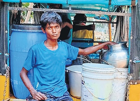 A man getting water in containers in Nagulapalli village of Kakinada 