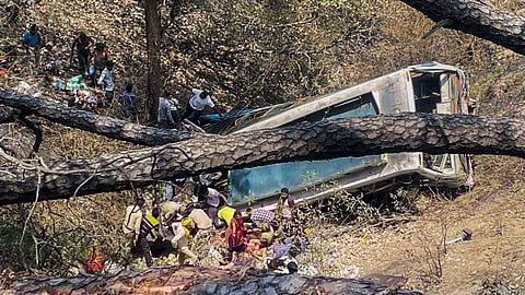 Police personnel and civilians near the wreckage of the bus which skidded off the road and fell into a gorge at Chowki Choura, in Jammu district, Thursday, May 30, 2024. At least 7 pilgrims were killed and 23 injured in the accident, according to officials. 