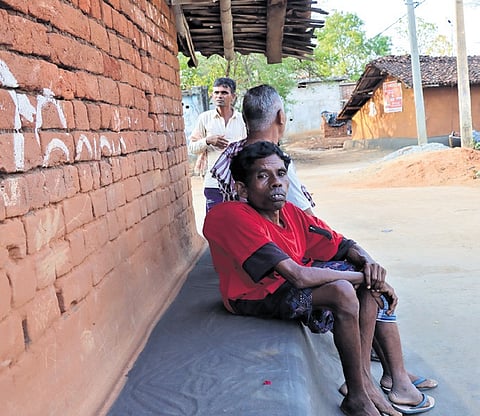 Physically-challenged Rupa Tandi who has been left behind by his family, sitting in front of his house at Karuanmunda village in Kantabanji