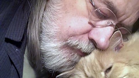 This undated self portrait made available by Little Brown publisher, shows author Caleb Carr and his cat Masha at his home in Cherry Plain, NY.