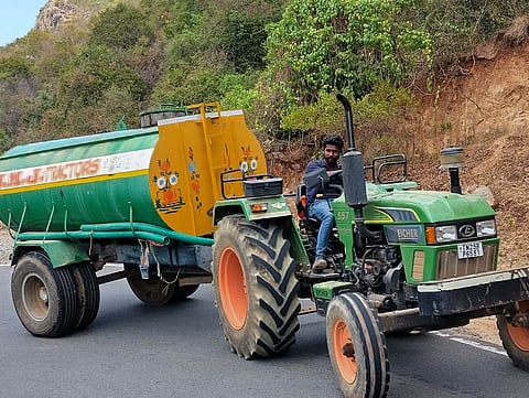A private water supplier climbing the uphill road on his tractor to supply water to the tribal hamlet in Vathalmalai.