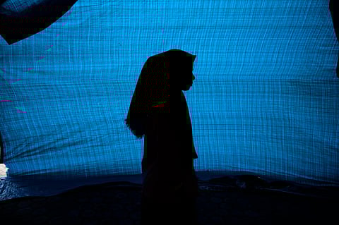 N, a 12-year-old ethnic Rohingya refugee identified by The Associated Press with only an initial, because she is a sexual assault survivor, stands in her tent at a temporary shelter on April 4, 2024.