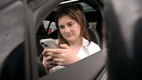 Alexis Bogan, whose speech was impaired by a brain tumour, uses an AI powered smartphone app to create a audible drink order at a Starbucks drive-thru on Monday, April 29, 2024, in Lincoln, R.I.
