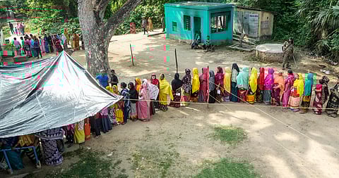 People wait in queues to cast their votes at a polling station during the sixth phase of Lok Sabha elections, in Purba Medinipur district, Saturday, May 25, 2024.