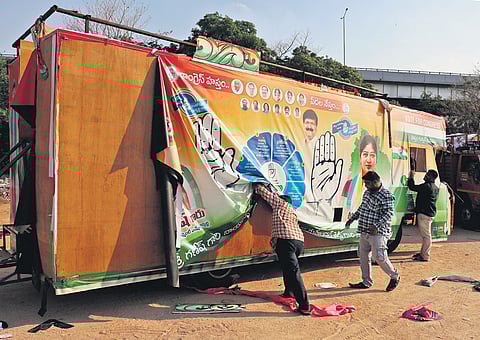 With the silence period in force, workers remove a political banner from a DCM vehicle at NTR Stadium in Hyderabad on Saturday 