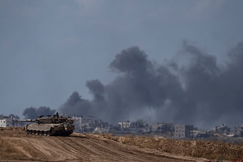 Backdropped by smoke rising to the sky after an explosion in the Gaza Strip, an Israeli tank stands near the Israel-Gaza border as seen from southern Israel, Monday, May 13, 2024.
