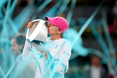 Poland's Iga Swiatek kisses the trophy after winning the women's final match against Aryna Sabalenka of Belarus, at the Mutua Madrid Open tennis tournament in Madrid on May 4, 2024.