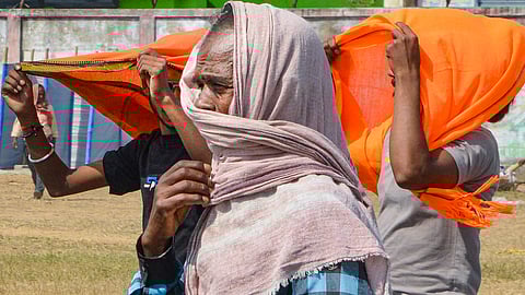 People cover their head with scarves to protect from the scorching heat on a hot summer day.