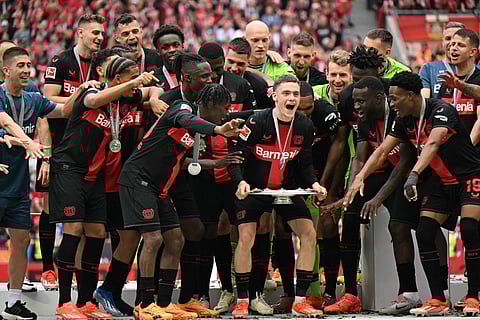 Bayer Leverkusen's German midfielder Florian Wirtz and his teammates celebrate with the Bundesliga trophy on May 18, 2024.