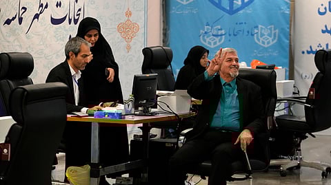 Former Iranian lawmaker Mostafa Kavakebian, the Secretary General of Mardomsalari, or Democracy, party flashes a victory sign while registering his name as a candidate.