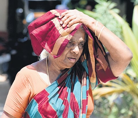 An old woman protecting herself from scorching heat in Tirupati 