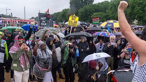 People raise their fists in solidarity during a pro-Palestinian rally, Saturday, May 18, 2024, on the National Mall near the Capitol in Washington.