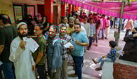 People wait in a queue to cast their vote at a polling station, during the sixth phase of Lok Sabha elections, in New Delhi, Saturday, May 25, 2024.