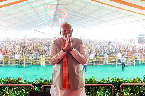Prime Minister Narendra Modi greets during the public meeting ahead of the seventh phase of Lok Sabha Polls, in Mirzapur on Sunday.