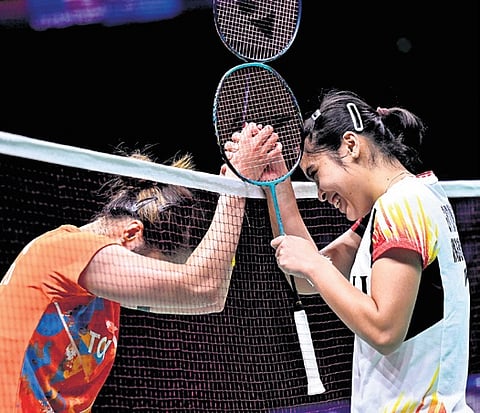 Ratchanok Intanon (L) shakes hands with Gregoria Mariska Tunjung