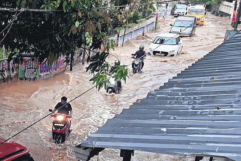 Motorists wade through the waterlogged Pipinmoodu-Kowdiar road in Thiruvananthapuram following heavy rain 
on Thursday. 
