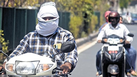 Commuters cover their faces to avoid seering sun amid raging heatwave