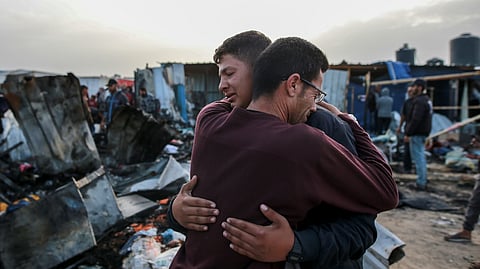 Palestinians react next to the destruction after an Israeli strike where displaced people were staying in Rafah, Gaza Strip.