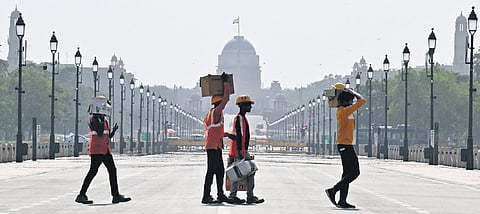 Children bathe from a pipe on a hot summer day amid heatwave.