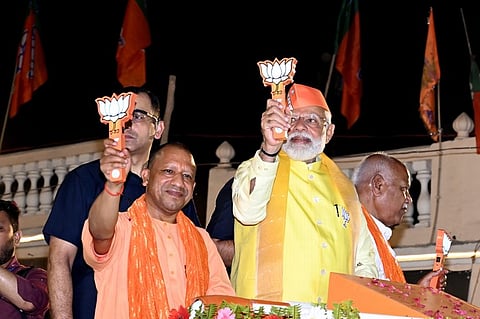 Uttar Pradesh Chief Minister Yogi Adityanath along with Prime Minister Narendra Modi during a roadshow for the Lok Sabha elections, in Varanasi.