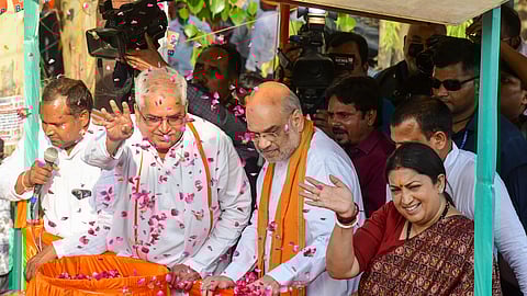 Union Home Minister Amit Shah with Union Minister and BJP candidate from Amethi constituency Smriti Irani and others during an election roadshow for the Lok Sabha polls, in Amethi district, Saturday.