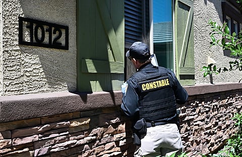 Lennie McCloskey, Constable of Manistee Justice Precint in Maricopa County, talks with a family he is trying to evict.