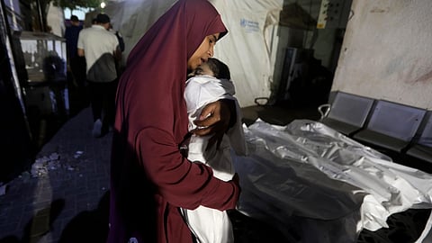 A Palestinian woman mourns her relative, 7-month old baby Hani Qeshta, who was killed in an Israeli bombardment on a residential building with Qeshta's family, at the morgue of Al Najjar hospital in Rafah, southern Gaza Strip.