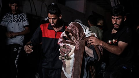 Palestinians rescue a woman survived after the Israeli bombardment on a residential building of Abu Alenan family in Rafah.