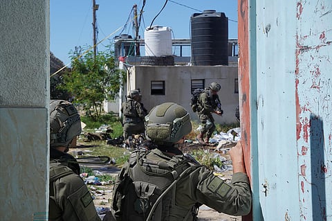 Israeli soldiers work on armored military vehicles at a staging ground near the Israeli-Gaza border, in southern Israel, Wednesday, May 8, 2024. 