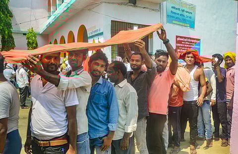 People wait to cast their votes at a polling booth during sixth phase Lok Sabha elections in East Champaran, Bihar, Saturday, May 25, 2024.