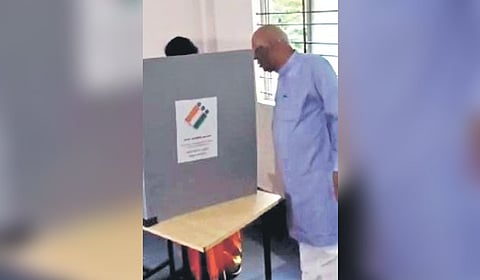 A screengrab showing MP Siddeshwara allegedly peeping into the voting booth when his wife and BJP candidate Gayatri was voting, on Tuesday  