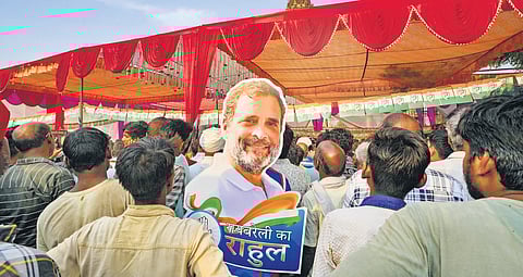 A supporter holds a cutout of Congress leader Rahul Gandhi during a public rally in Rae Bareli.