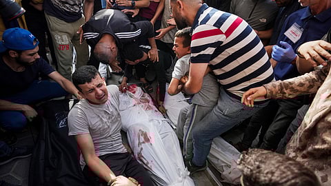 Palestinians react next to the bodies of their relatives who were killed in an Israeli airstrike in Gaza Stirp.