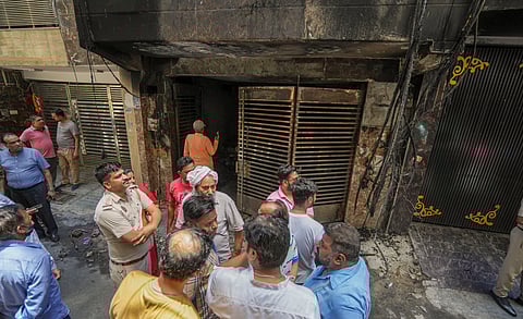 Locals gather after a fire broke out in a residential building, at Krishna Nagar area in East Delhi, Sunday, May 26, 2024. At least three people were killed, according to officials.