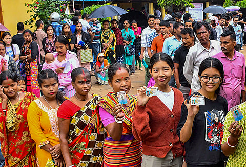 Voters wait in queues at a polling station during the 3rd phase of Lok Sabha polls, in Guwahati.