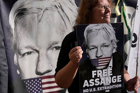 Protesters hold placards outside the High Court in London, Monday, May 20, 2024.
