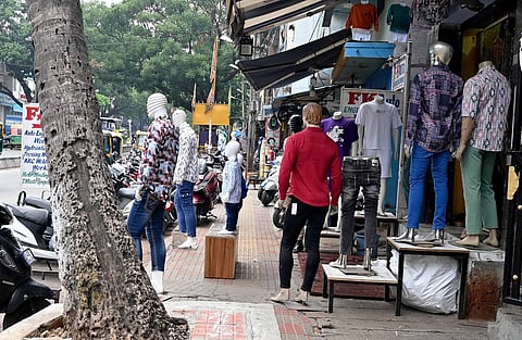 Pedestrians are unable to walk on the footpath as shopkeepers have encroached it, at Jayanagar East in Bengaluru.