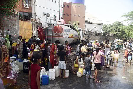 Locals at Chanakyapuri's Sanjay Camp collect drinking water from a tanker amid water crisis in Delhi, on Wednesday.