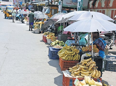 Fruit vendors seen protecting themselves from scorching heat in Tirupati