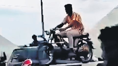 Youth riding a motorcycle on the median of the Kollidam river bridge in Tiruchy 