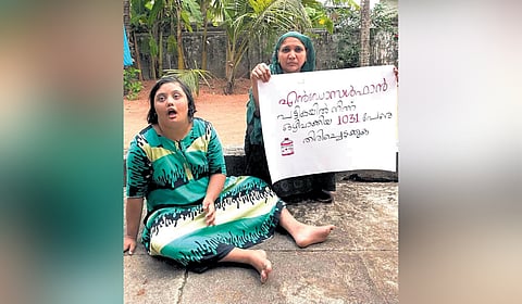Murshitha and her mother with a placard demanding inclusion of 1,031 endosulfan affected individuals in the list of victims 