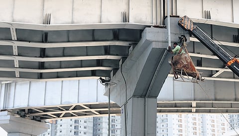 With the monsoon nearing, a worker fixes pipes for drainage from the flyovers at Kondapur in Hyderabad 
