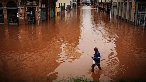 A man wades through an area flooded by heavy rains, in Porto Alegre, Rio Grande do Sul state, Brazil.